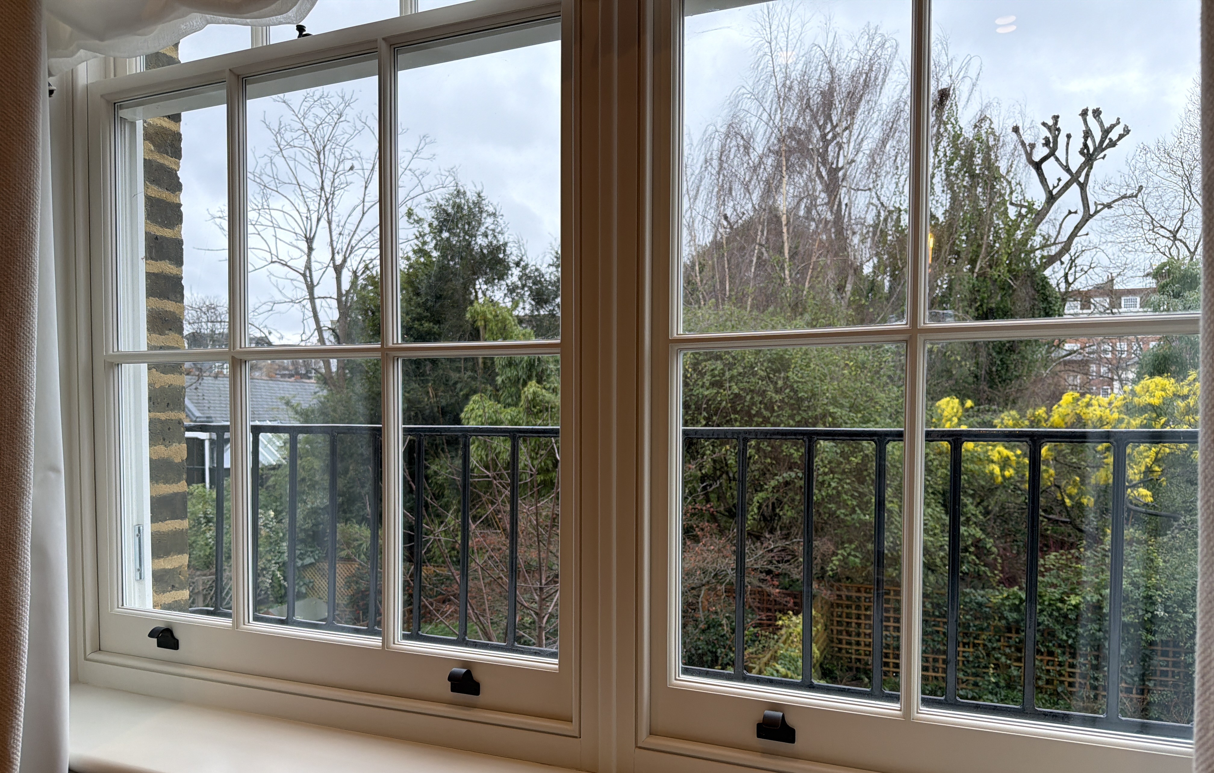 Restored timber sash windows by Kensington Sash, looking out over a West London garden